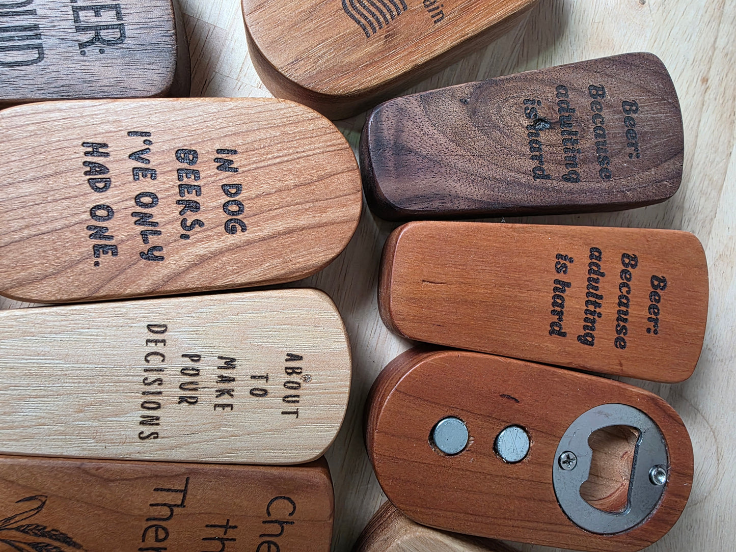 Wooden keychains with engraved text on a light wooden surface