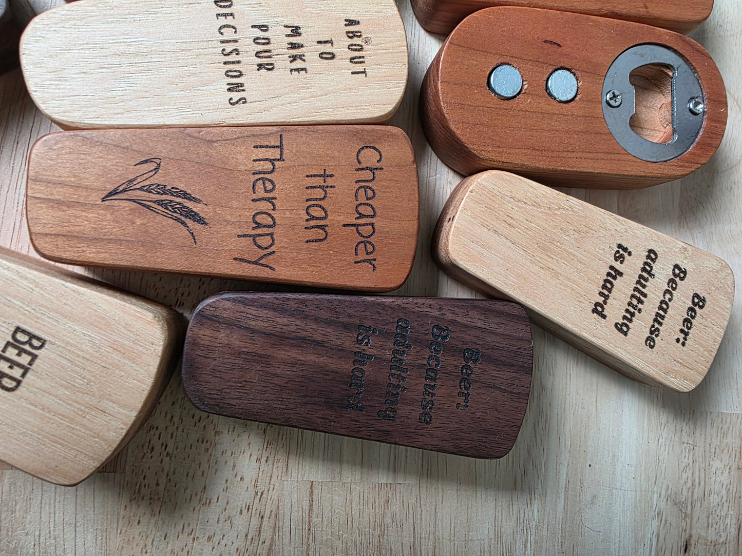 Wooden bottle openers with engraved text on a wooden surface
