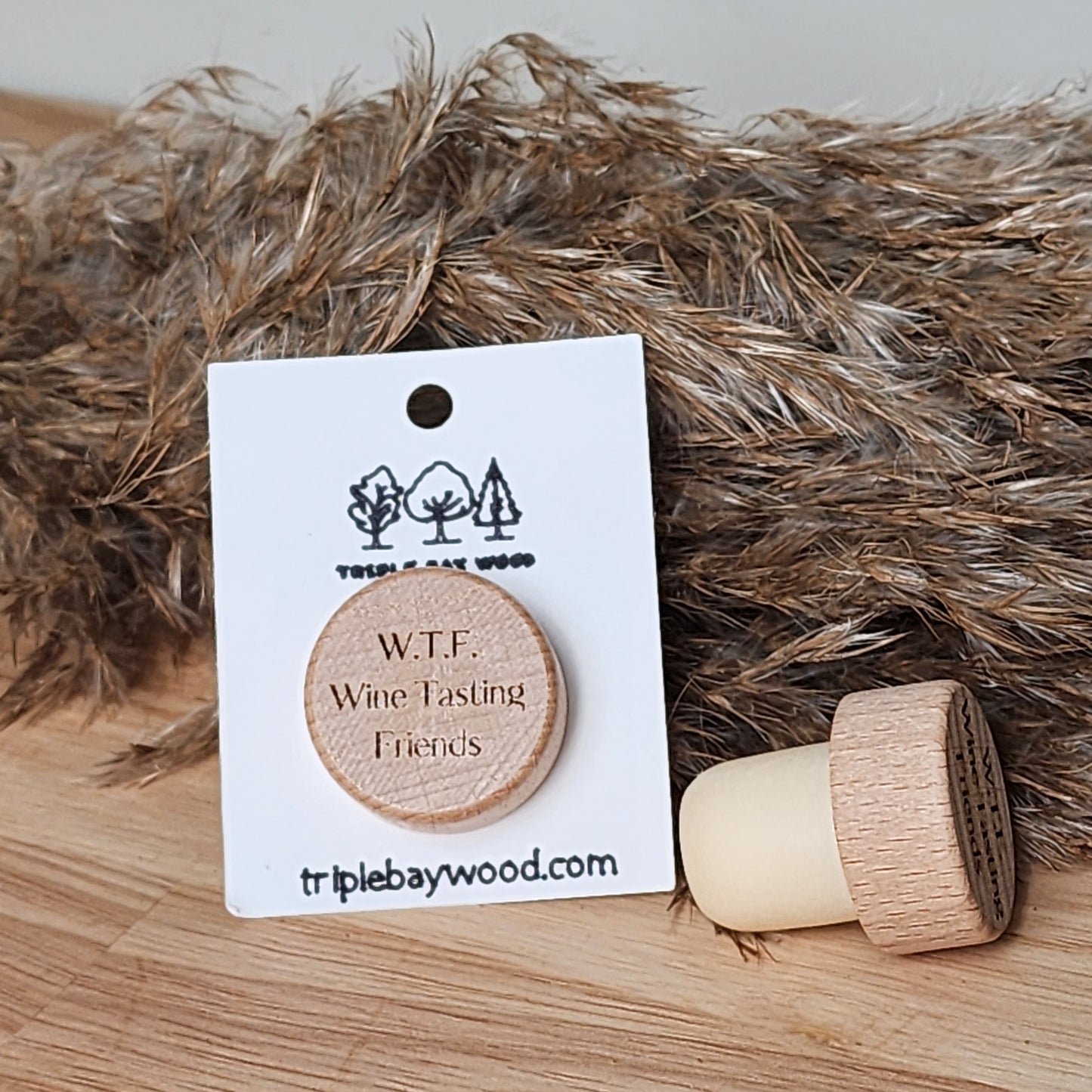 A wooden wine stopper with the inscription 'W.T.F. - Wine Tasting Friends'
