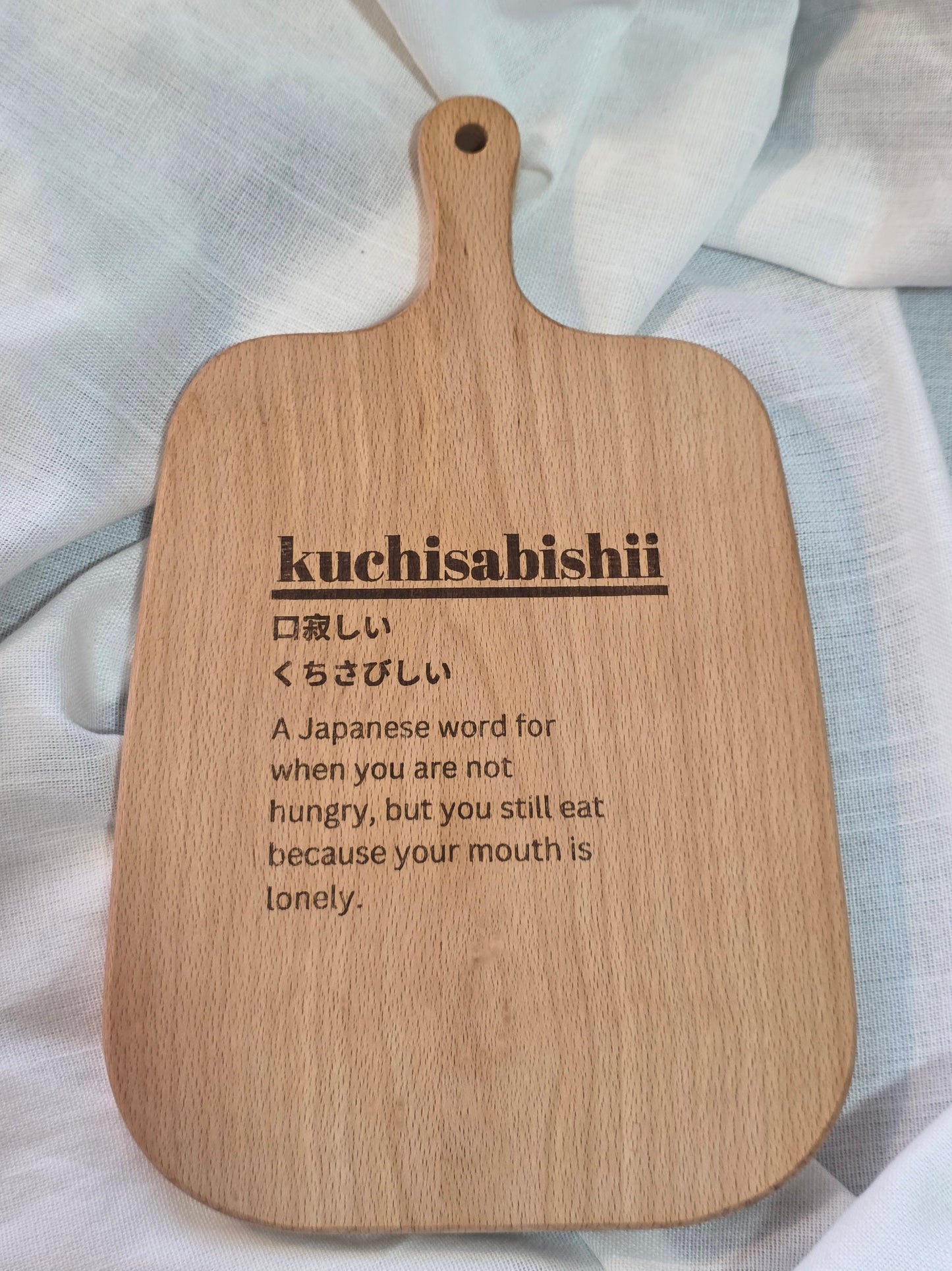 Wooden paddle with engraved text on a light fabric background