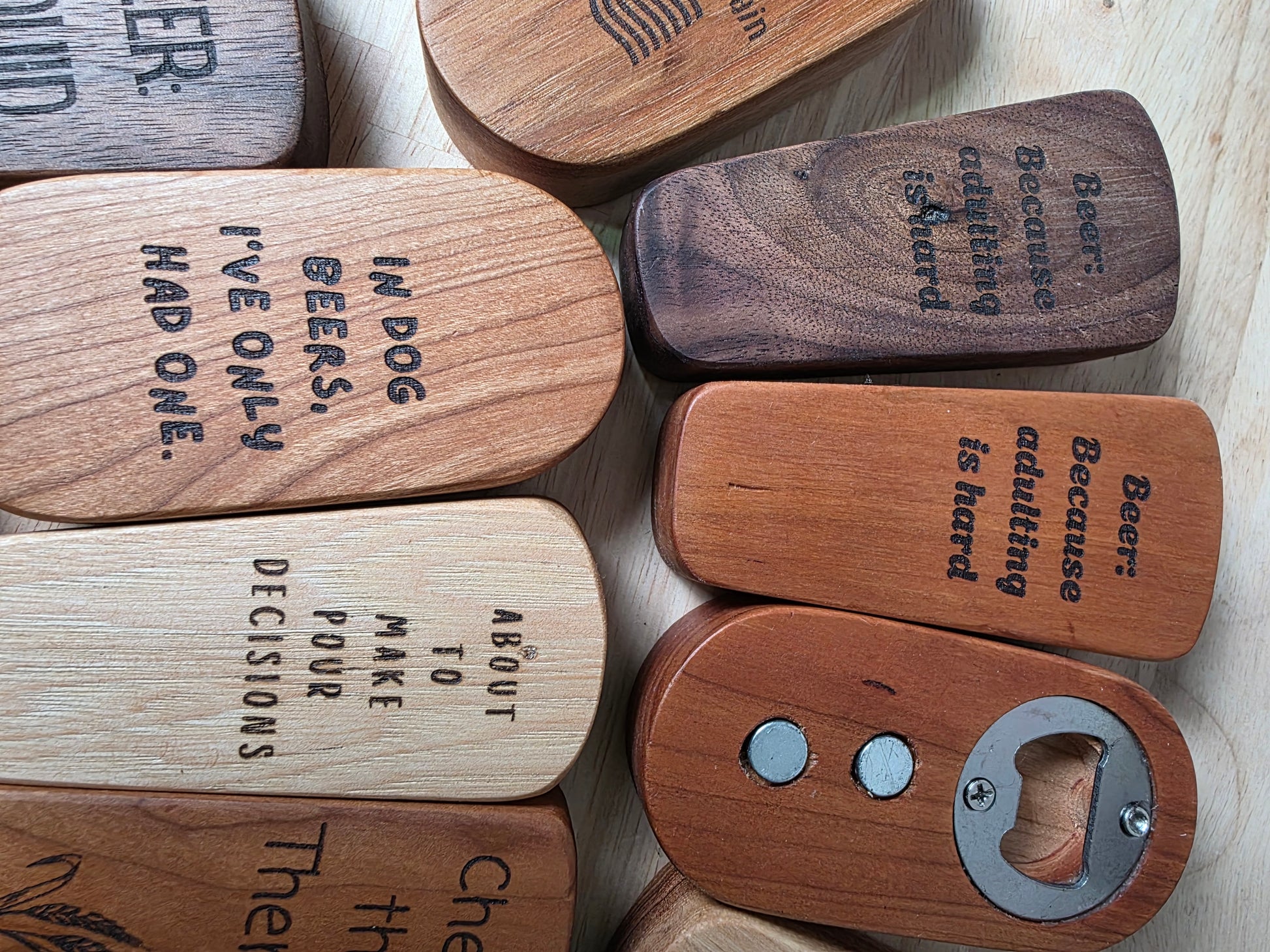 Wooden keychains with engraved text on a light wooden surface