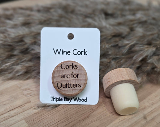 Wine cork with a humorous message on a white card, set against a textured brown background.