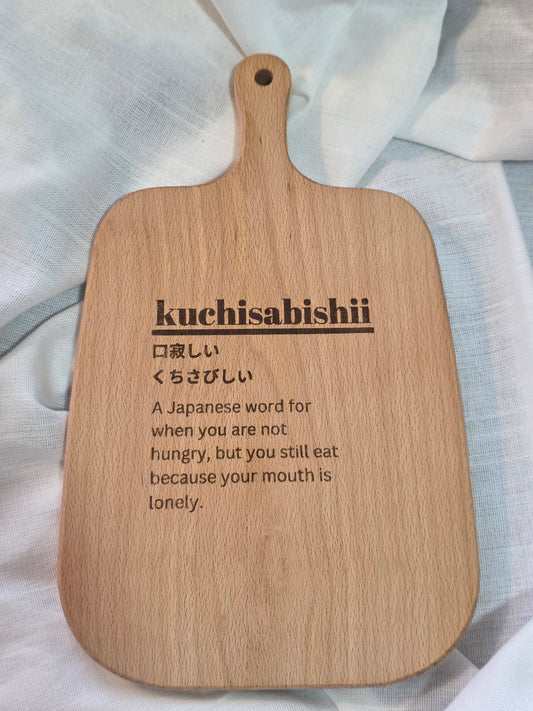 Wooden paddle with engraved text on a light fabric background
