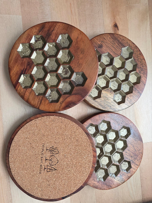 Wooden grinders with honeycomb design on a wooden surface, featuring the brand 'Triple Bay Wood'.