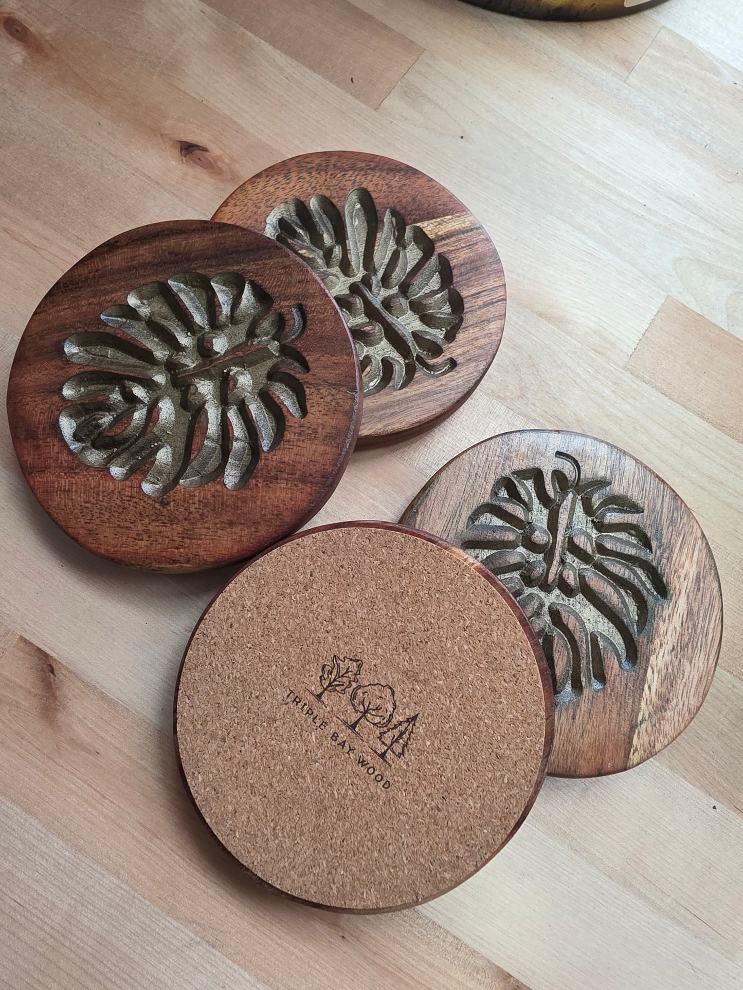 Wooden coasters with embossed designs on a wooden surface