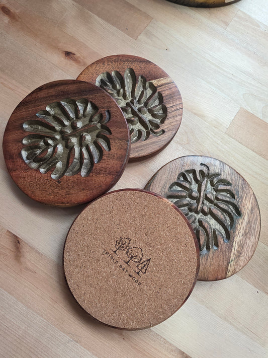 Wooden coasters with embossed designs on a wooden surface